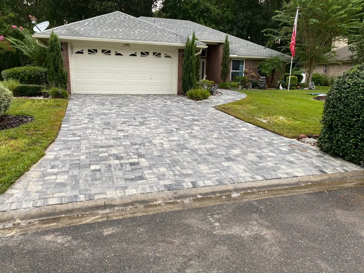 A paver driveway leading to a two-car garage