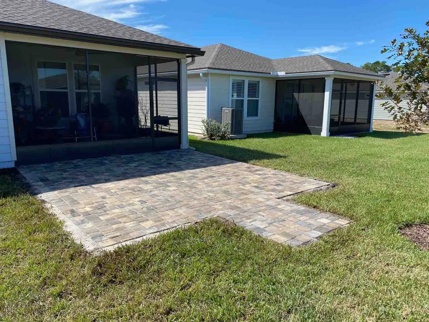 A paver patio pad beside a screened porch